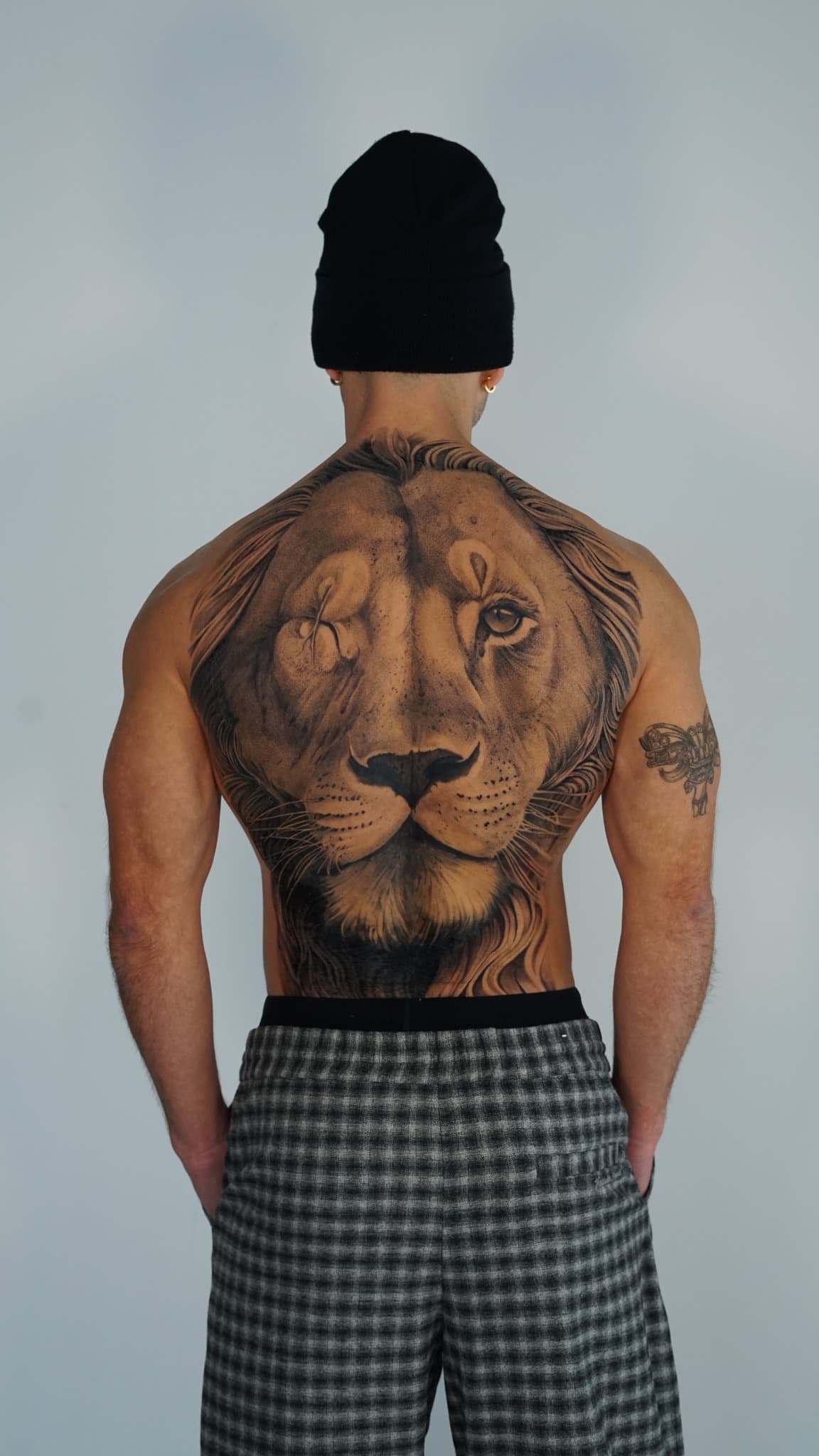 Realistic black and grey lion back tattoo by Tonymontattoo